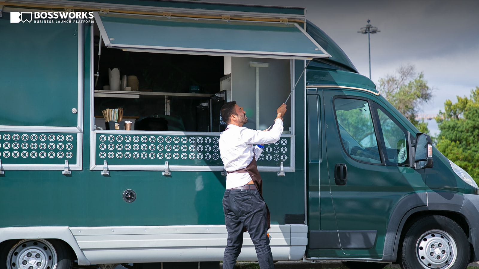 Food truck owner opening service window on teal food truck